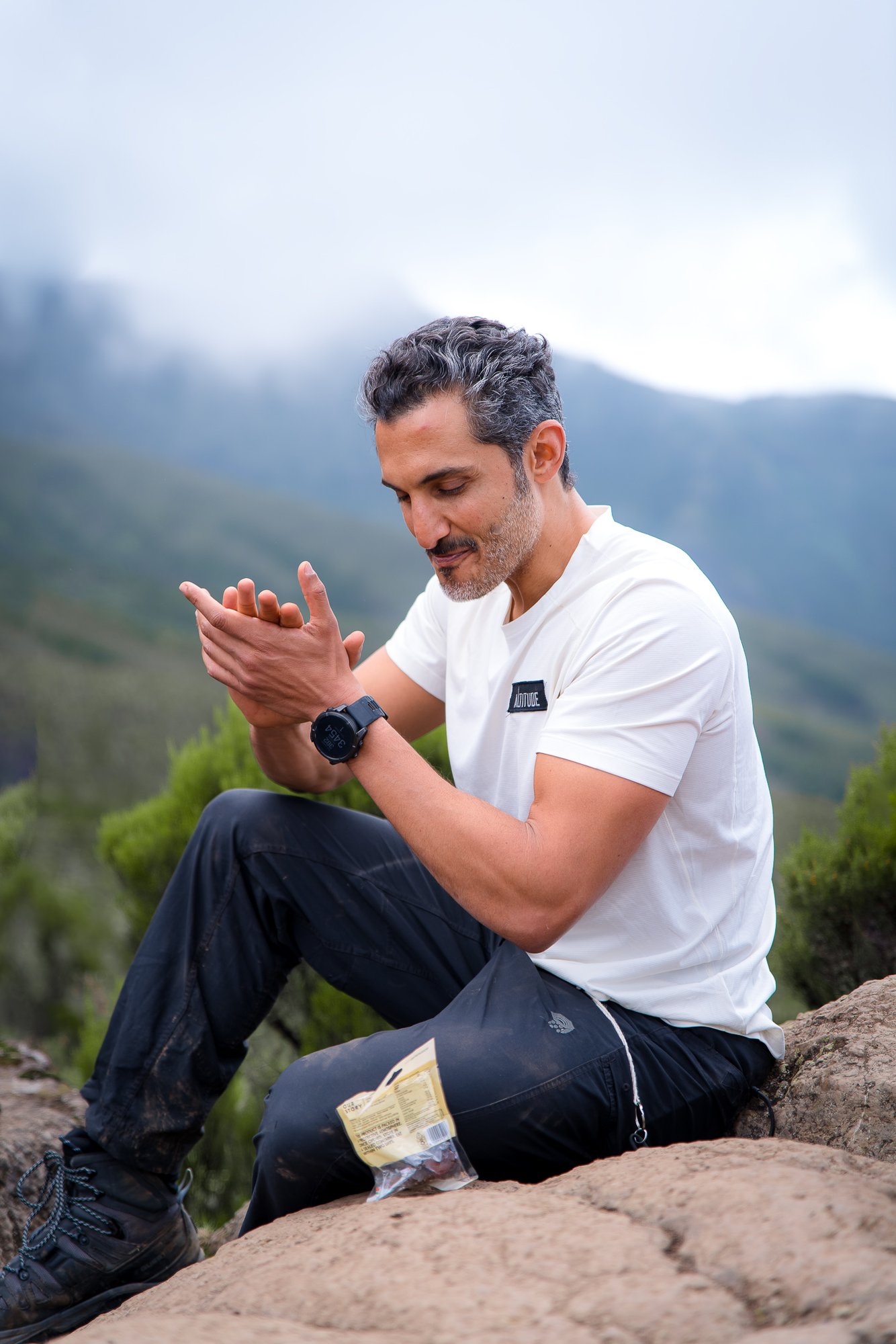 Moe sitting on a rock taking a break on the mountain
