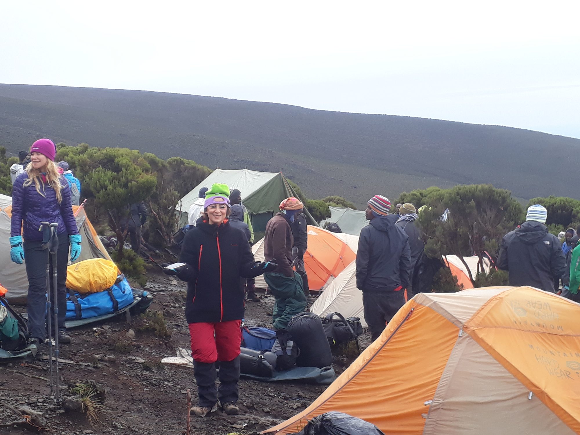 Climbers among orange tents at camp