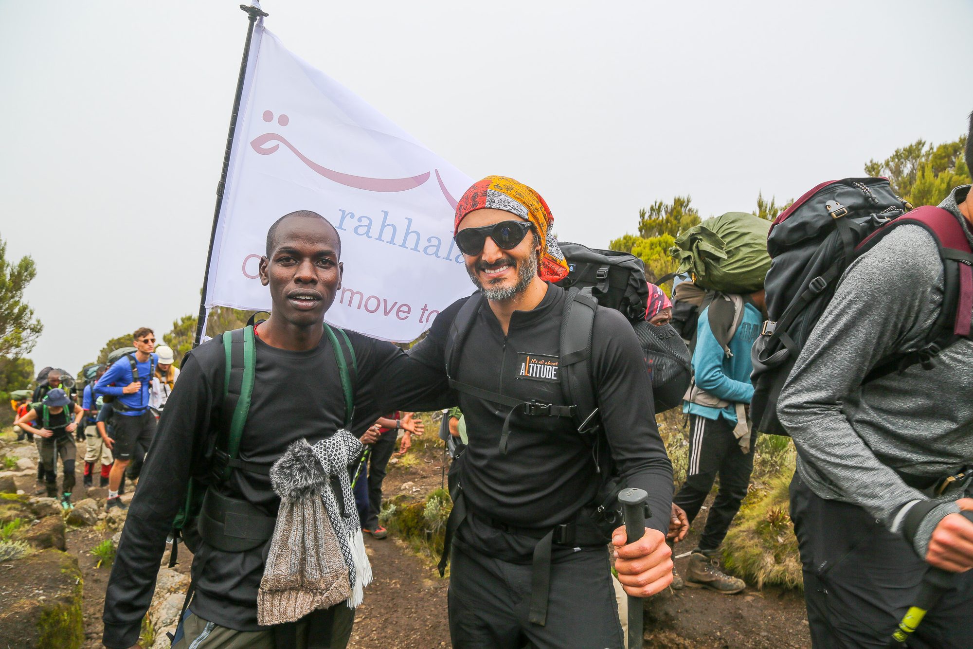 Climbers walking together with a Rise to Success flag