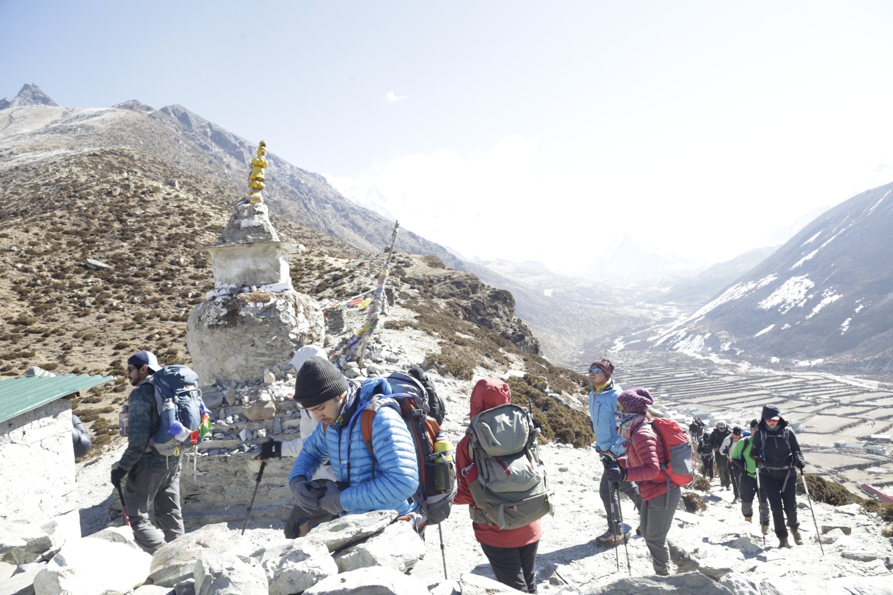 Trekkers pausing together beside a stone monument