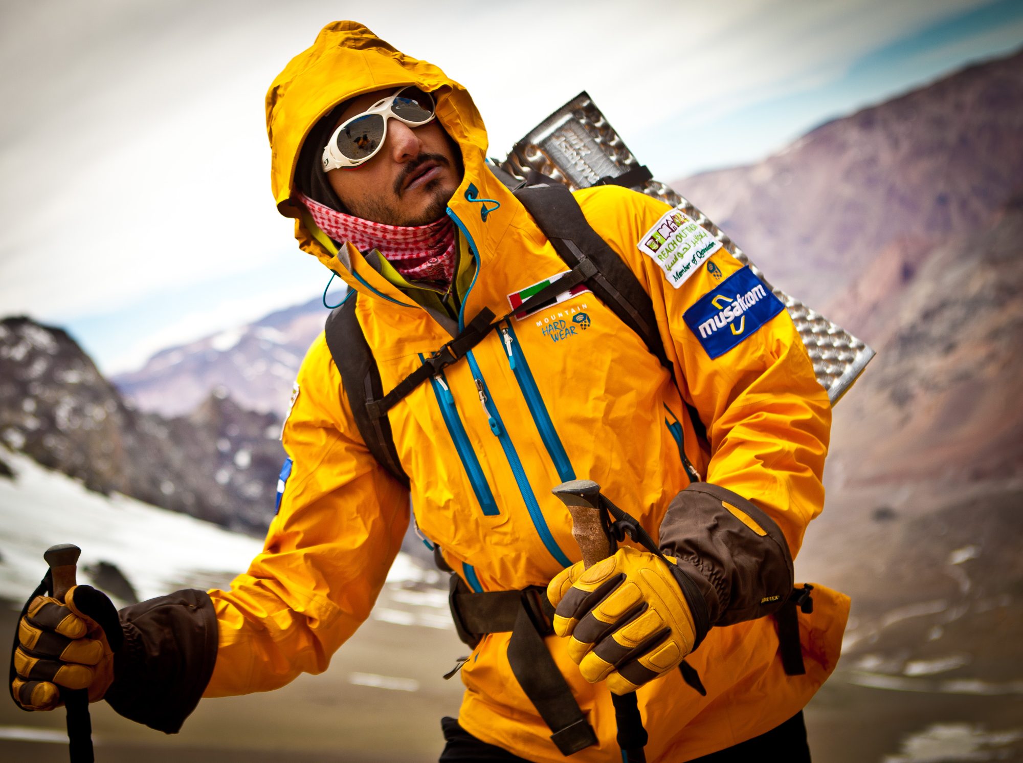 Moe in a yellow jacket and glacier glasses
