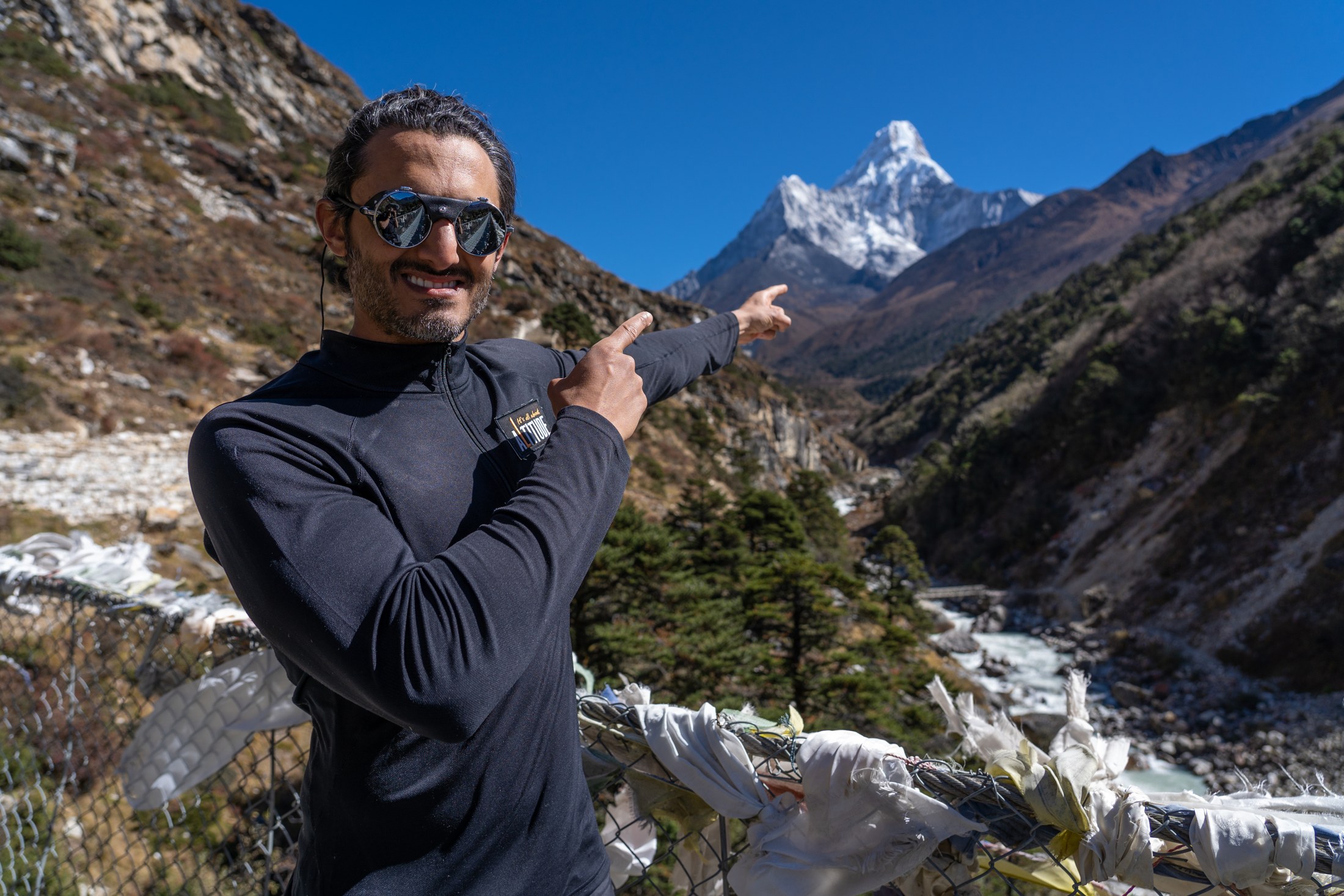 Moe on a mountain trail, surrounded by snowy peaks