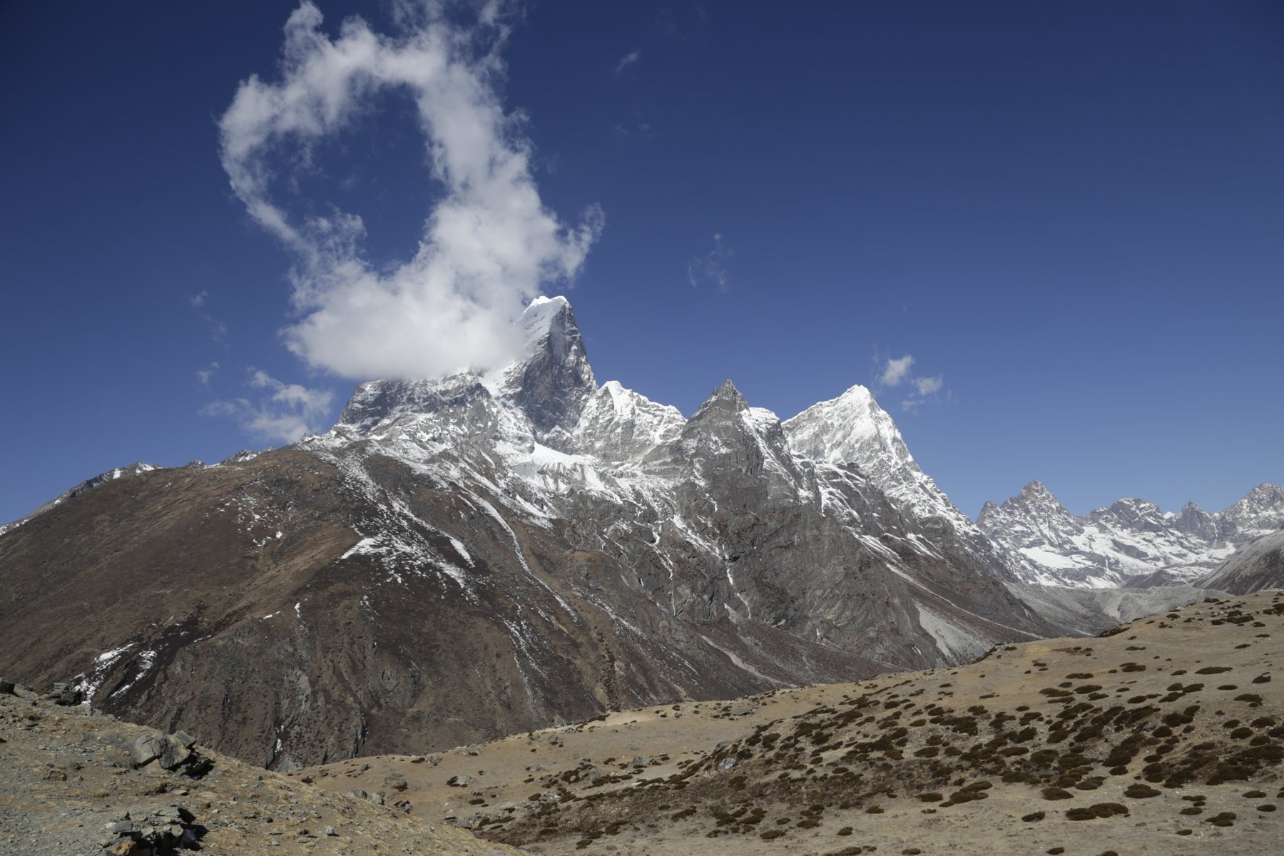 Clouds rising above a sharp snow-covered Himalayan peak