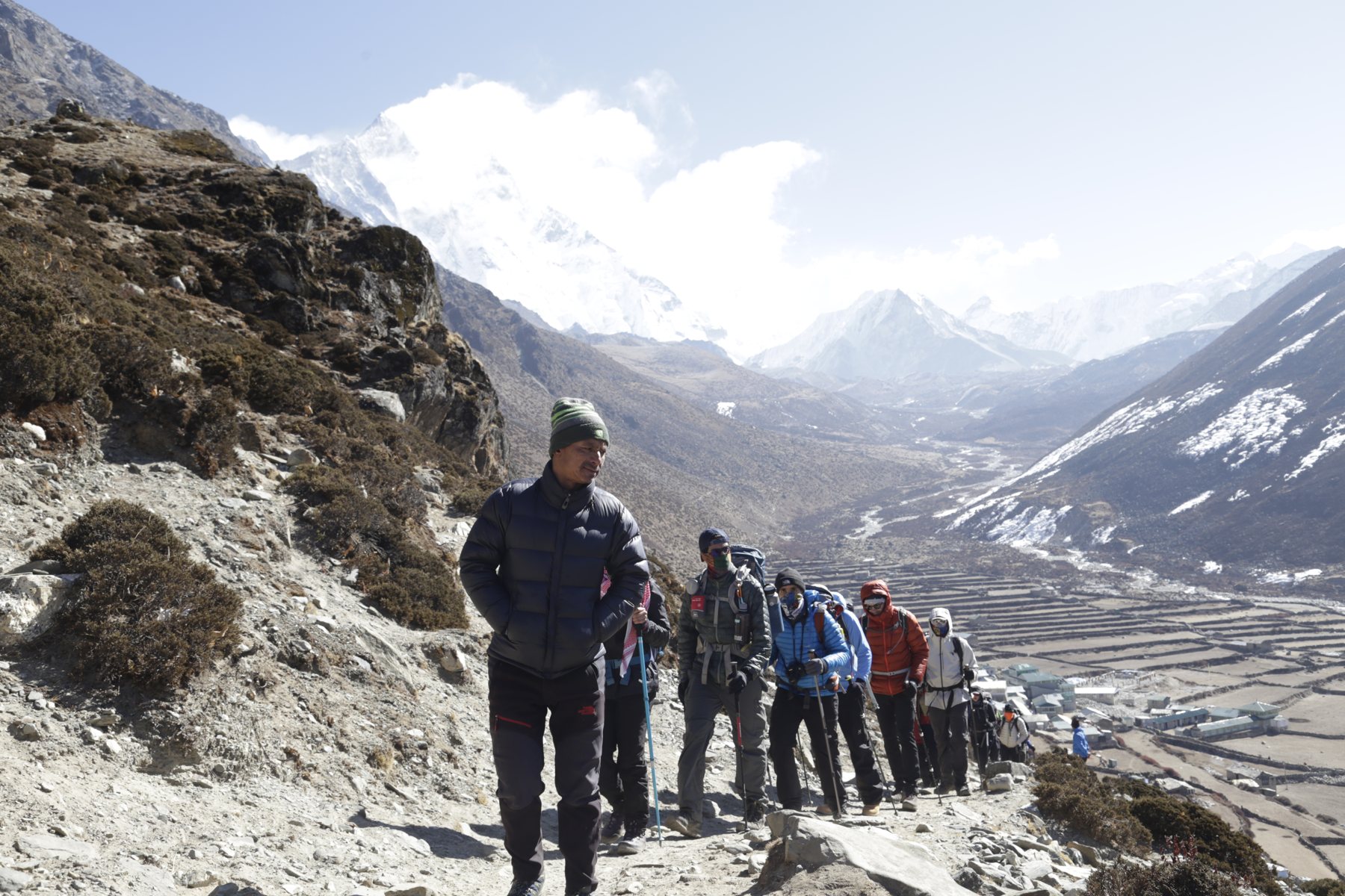 A group climbing the trail together above the valley